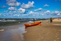 An orange lifeguard boat on a beach in ÃÂeba in Poland on a warm day